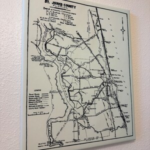 May include: A black and white map of St. Johns County, Florida, showing roads, rivers, and towns. The map includes a legend with road types and county road numbers. The map is dated 1921.