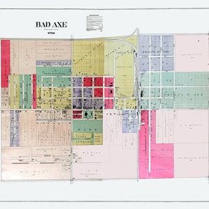 May include: A vintage map of Bad Axe, Michigan from 1904. The map is color-coded and shows the layout of the town with streets, blocks, and property lines. The map includes the names of streets and businesses.