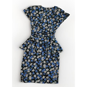 Puede incluir: Un vestido negro con estampado floral con flores azules y blancas. El vestido tiene mangas cortas, cintura ceñida y un detalle de peplum en las caderas. La tela parece ligera.
