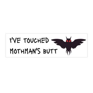 May include: A white rectangle with the text "I'VE TOUCHED MOTHMAN'S BUTT" in black. A black silhouette of a Mothman with red eyes is on the right side of the rectangle.