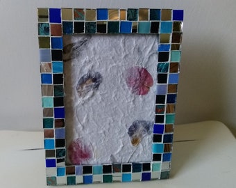 May include: A blue and silver mosaic picture frame with a white background. The frame is made of small, square tiles in shades of blue, green, and brown.