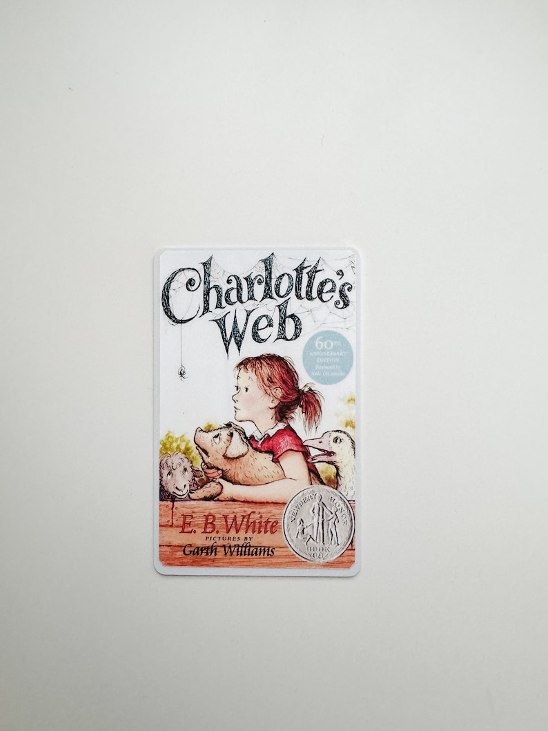 May include: A book cover for Charlotte's Web by E.B. White, illustrated by Garth Williams. The cover features a young girl with a pig, a lamb, and a spider.
