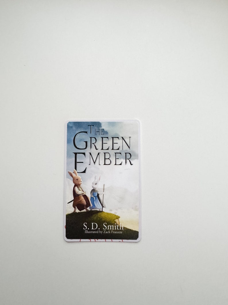 May include: A book cover with a white background and blue clouds. The title "The Green Ember" is in black text. Two white rabbits are walking on a green hill. The author is S.D. Smith and the illustrator is Zach Franzen.