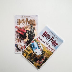 May include: Two paperback books featuring the Harry Potter series by J.K. Rowling. The first book is "Harry Potter and the Philosopher's Stone" and the second book is "Harry Potter and the Chamber of Secrets, Part 2".