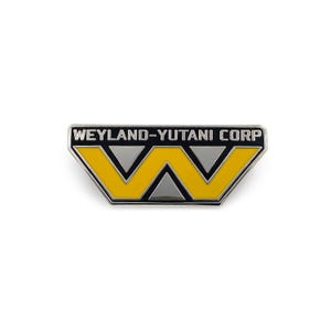 Peut inclure: Une épingle en métal argenté avec un logo noir et jaune. Le logo est un "W" stylisé avec le texte "Weyland-Yutani Corp" au-dessus.
