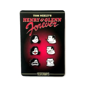 Puede incluir: Un conjunto de seis pines de esmalte con personajes de dibujos animados en blanco y negro con acentos rojos. Los pines están dispuestos en dos filas de tres. Los pines están sobre un fondo negro con el texto "TOM NEELY'S HENRY & GLENN Forever" y "YESTERDAYS" en blanco.