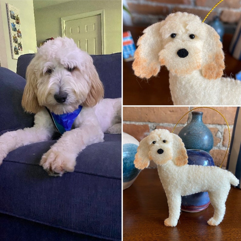 Pode incluir: Um enfeite de cachorro creme com orelhas castanhas e nariz preto. O enfeite &eacute; feito de material macio e tem um fio dourado para pendurar. A imagem tamb&eacute;m mostra um cachorro vivo com uma colora&ccedil;&atilde;o semelhante.