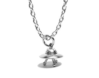 May include: A silver chain necklace with a small silver UFO pendant.