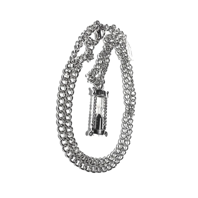 May include: A silver chain necklace with an hourglass pendant.