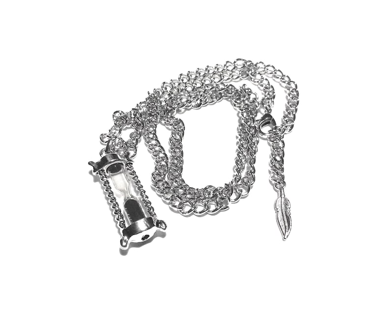 May include: A silver chain necklace with a silver hourglass pendant and a silver feather charm.