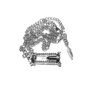 May include: A silver chain necklace with an hourglass pendant. The hourglass is filled with sand and has a silver feather charm attached to the chain.