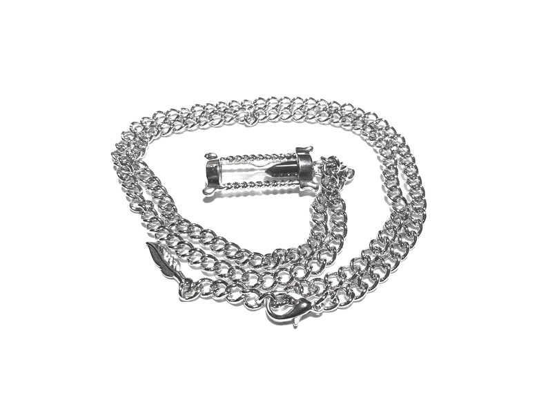 May include: A silver chain necklace with a silver hourglass pendant.