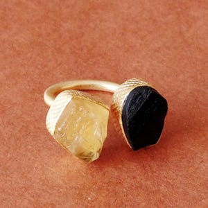 Peut inclure: Bague en or avec une pierre jaune et noire. Les pierres sont taillées dans une forme brute et naturelle.