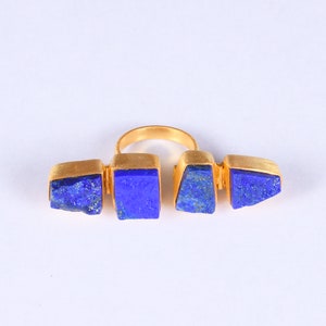 Puede incluir: Anillo de oro con tres piedras azules de lapislázuli engastadas en un diseño geométrico.