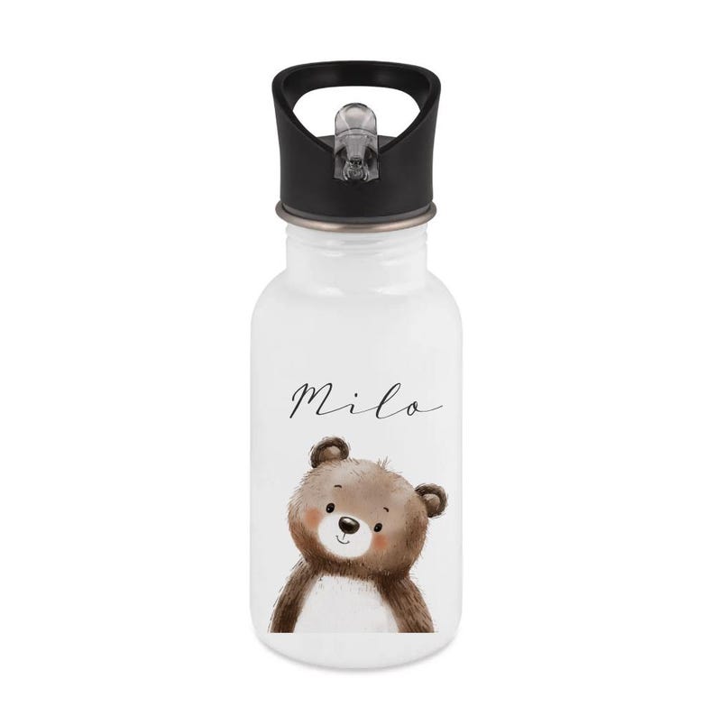 May include: White water bottle with a black lid and a flip-top spout. The bottle features a watercolor illustration of a brown teddy bear and the name "Milo" in a cursive font. The bottle is designed for kids.