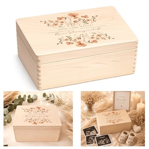 Könnte beinhalten: Eine rechteckige Aufbewahrungsbox aus hellem Holz mit Klappdeckel. Der Deckel ist mit einem Aufdruck aus zarten braunen und orangefarbenen Blumen sowie dem deutschen Text "WENN LIEBE WACHST" und "Meine Schwangerschaft" in Schreibschrift versehen.