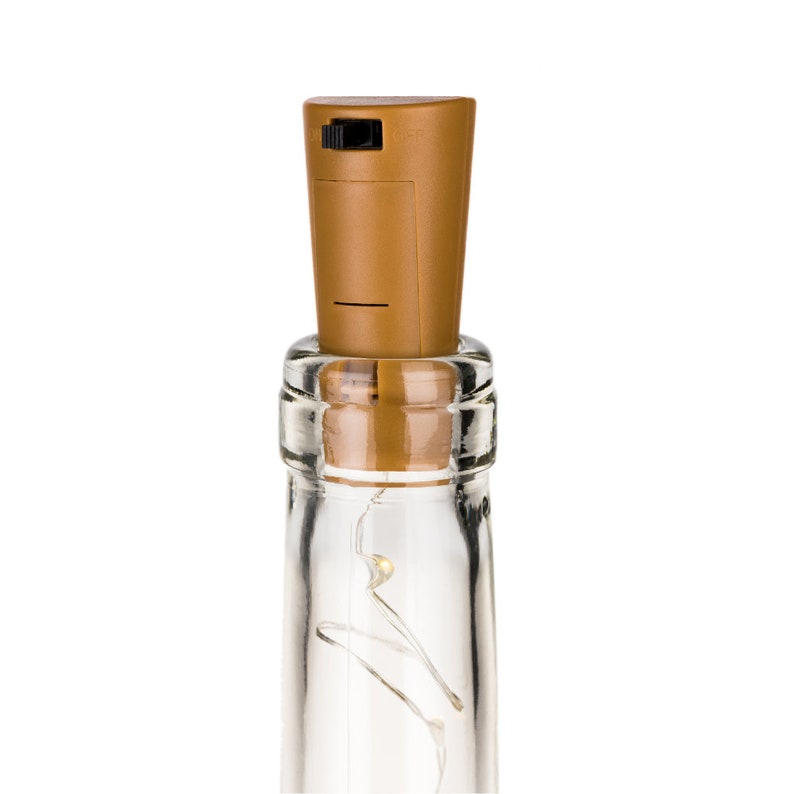May include: A brown bottle stopper with a built-in LED light. The stopper is on top of a clear glass bottle with a string of lights inside.
