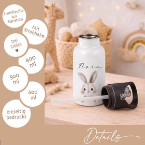 May include: White stainless steel water bottle with a black lid and a straw. The bottle features a cute bunny illustration and the name "Nora". The bottle is available in 400ml, 500ml, and 600ml sizes.