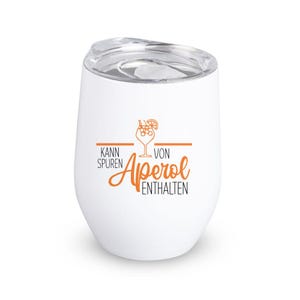 May include: White insulated tumbler with a clear lid. The tumbler features the words "Kann Spuren von Aperol Enthalten" in orange and black, along with a graphic of a cocktail. The tumbler is designed to keep drinks cold.