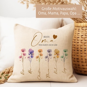 May include: Beige throw pillow with floral design and text. The pillow features watercolor flowers in pink, purple, orange, yellow, and green. Text includes "Oma" and "Wir haben dich lieb."