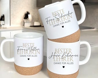 May include: White ceramic mugs with cork bases. Each mug has a handle and features text in black and tan, including "BESTE LEHRERIN" and "DANKE FÜR ALLES". A small black heart is also present on each mug. The mugs are stacked.