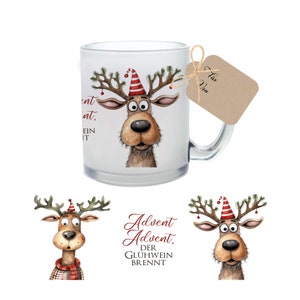 May include: A clear glass mug featuring a cartoon reindeer with a red and white hat and festive antlers. The mug has a handle and a tag tied to it. The reindeer design is whimsical.