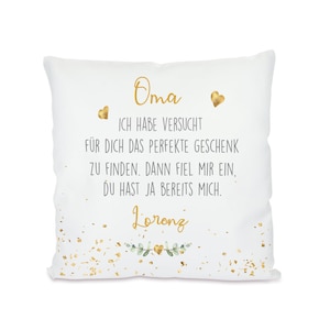 May include: White pillow with gold lettering that reads "Oma ICH HABE VERSUCHT FÜR DICH DAS PERFEKTE GESCHENK ZU FINDEN. DANN FIEL MIR EIN, DU HAST JA BEREITS MICH. Lorenz" with gold confetti and green leaves.