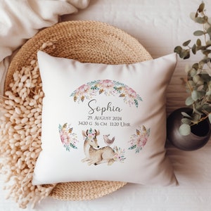 Puede incluir: Almohada blanca con un diseño floral y un ciervo con un pájaro en su espalda. La almohada tiene el nombre "Sophia" y el texto "29. AGOSTO 2024 3420 g 56 cm 11:20 UHR".