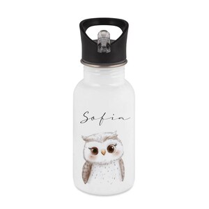 May include: White water bottle with a black lid and a cute owl illustration. The name "Sofia" is written in cursive above the owl. The bottle is designed for kids and has a flip-top lid.