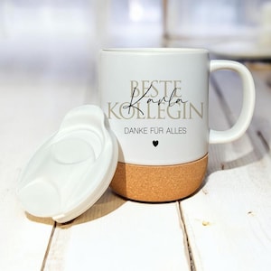 Könnte beinhalten: Weiße Keramiktasse mit Korkboden. Die Tasse hat den Text "Beste Karla Kollegin Danke für alles" in schwarzer und goldener Schrift mit einem kleinen schwarzen Herz.