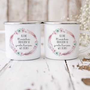 Puede incluir: Dos tazas de esmalte blanco con un dise&ntilde;o floral y el texto "KLEINE Menschen BRAUCHEN SO gro&szlig;e Herzen WIE DEINS!" impreso en ellas.