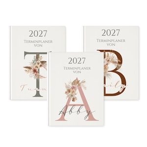 Op de afbeelding: Drie witte 2027 planners met grote schreefletters T, A en B in grijs, oudroze en bruin. Elke letter is versierd met een bloemstuk van gedroogde bloemen en grassen. De tekst op de covers luidt 2027 TERMINPLANER VON.