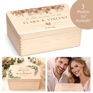 Könnte beinhalten: Eine hellfarbene Holzkiste mit Scharnierdeckel, mit floralen Designs und personalisiertem Text. Die Kiste ist rechteckig und hat Schwalbenschwanzverbindungen. Der Text auf der Kiste lautet "CLARA & VINCENT" und "26. JUNI 2026".