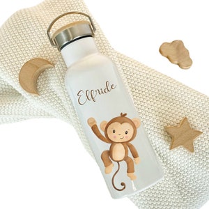May include: White stainless steel water bottle with a brown monkey graphic and the name "Elfride" printed on the front. The bottle has a bamboo lid and a carrying handle.