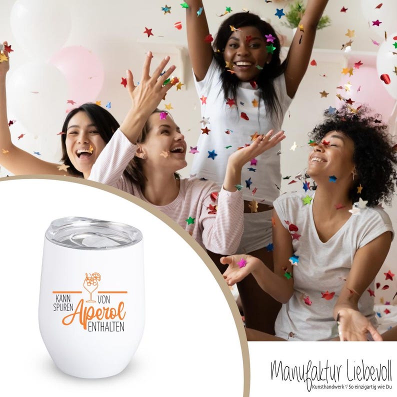 May include: White insulated wine tumbler with a silver lid. The tumbler has the words "Kann Spuren von Aperol enthalten" in orange and brown. The background shows a group of women celebrating with confetti.