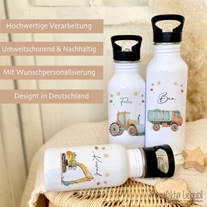 May include: Three white stainless steel water bottles with black lids and handles. Each bottle has a different design featuring a construction vehicle and a name: Felix, Ben, and Konnad. The bottles are decorated with gold stars.