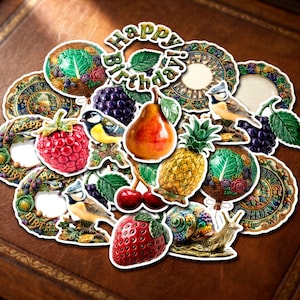 Peut inclure: Une collection d'autocollants d&eacute;coup&eacute;s pr&eacute;sentant diverses illustrations, notamment une poire, un ananas, une fraise, une framboise, des cerises, du raisin, un escargot, des m&eacute;sanges bleues et des assiettes circulaires avec le texte Happy Birthday.