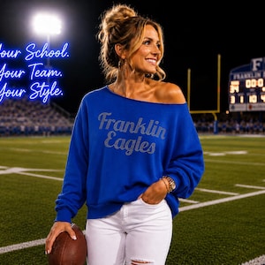 May include: A royal blue long-sleeve sweatshirt with a raw-edge neckline and the text Franklin Eagles in silver rhinestones across the chest. The text Your School. Your Team. Your Style. appears in blue neon script on the left side of the image.
