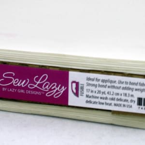 May include: A roll of white fusible bonding fabric labeled "Fusi-Bond Lite Iron-On Adhesive" by Sew Lazy. The label also includes the text "Ideal for applique. Use to bond fabric layers together. Strong bond without adding weight or stiffness. 17 in x 20 yd, 43.2 cm x 18.3 m. Machine wash cold delicate, dry delicate low heat. Made in USA. #SLG101"