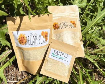 May include: Two brown paper pouches and one smaller brown paper sample packet containing a light-colored powder. The larger pouches feature labels reading Organic Dandelion Sugar with a flower graphic, and the sample packet is labeled Sample Dandelion.