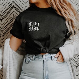 May include: A black t-shirt with the text "Spooky Season" in white lettering.