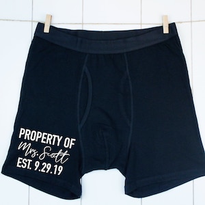 May include: Black boxer shorts with white text that reads "PROPERTY OF Mrs. Scott EST. 9.29.19".