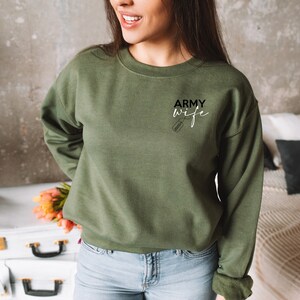 May include: A green sweatshirt with the text "ARMY wife" and a small dog tag graphic.