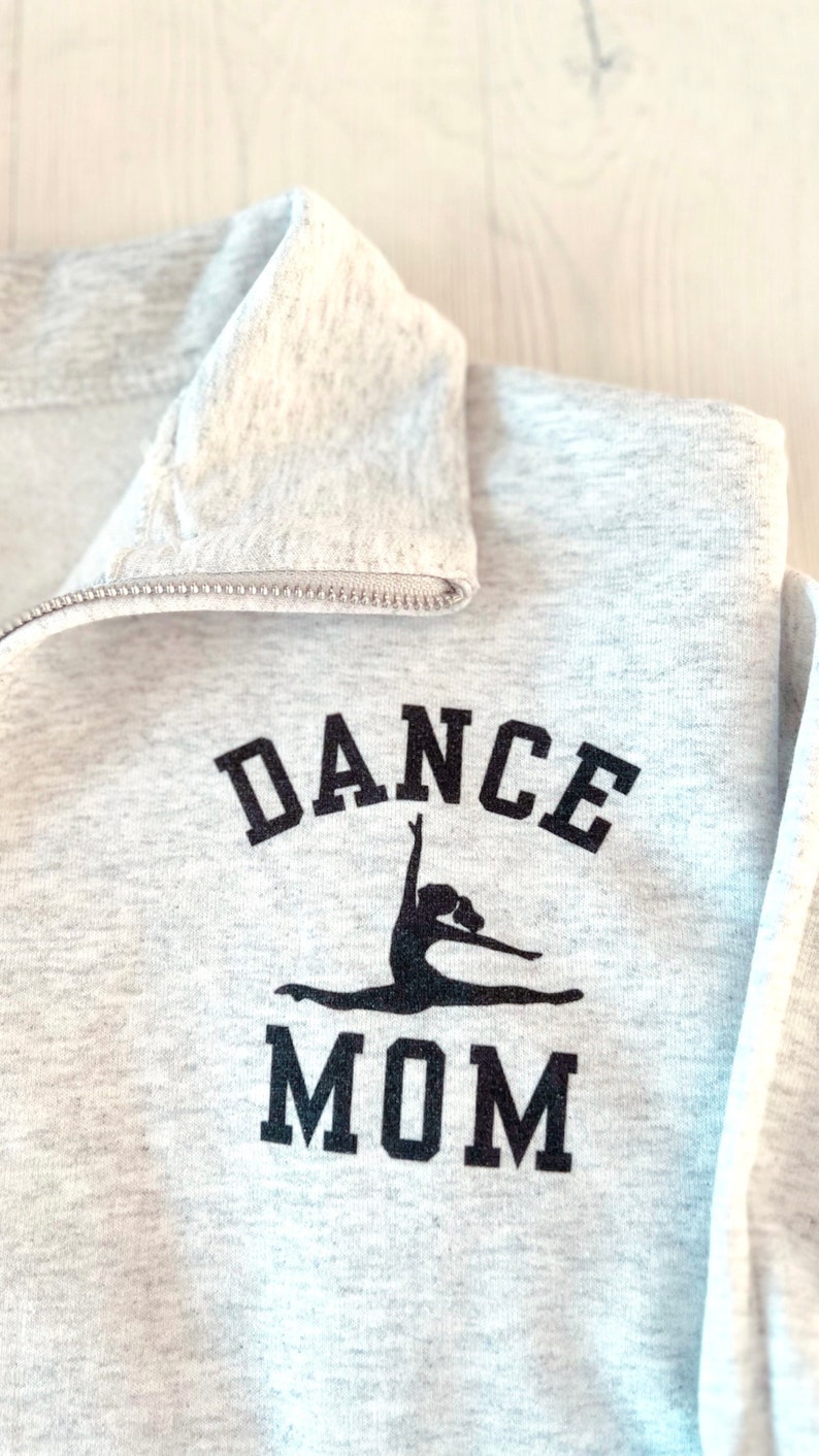 May include: Grey sweatshirt with a black graphic of a dancer and the text "DANCE MOM".