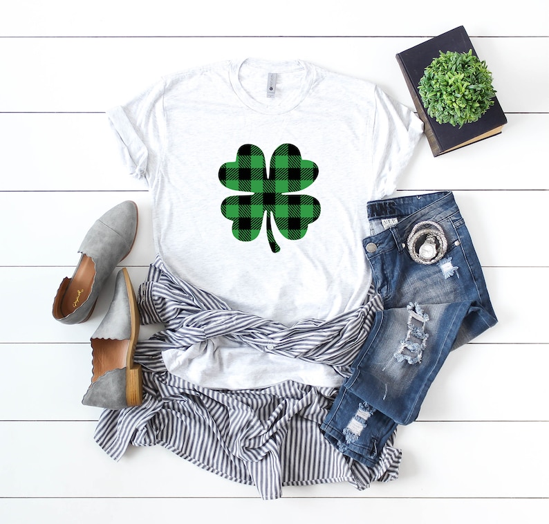 May include: A white t-shirt with a green and black plaid shamrock design.