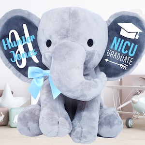 May include: Gray plush elephant with blue bow, personalized with the name "Hunter Jones" on one ear and "NICU GRADUATE" with a graduation cap on the other ear.