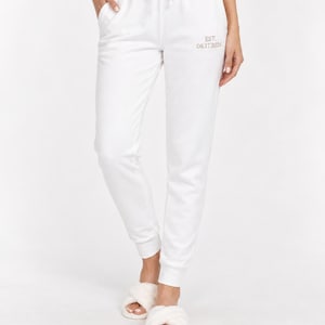 May include: White sweatpants featuring an elastic waistband with a drawstring and side pockets. The left thigh area displays the text EST. 08.17.2026 in a small, light-colored font. The pants have a tapered leg design with ribbed cuffs at the ankles.