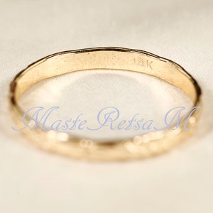 Puede incluir: Un anillo de banda de oro con una superficie texturizada y la inscripci&oacute;n "14K" en el interior. La inscripci&oacute;n "Masse Retssa M" tambi&eacute;n es visible en el interior del anillo.