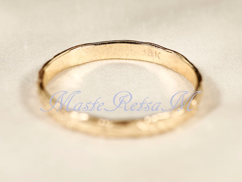 Puede incluir: Un anillo de banda de oro con una superficie texturizada y la inscripci&oacute;n "14K" en el interior. La inscripci&oacute;n "Masse Retssa M" tambi&eacute;n es visible en el interior del anillo.