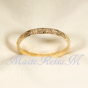 Puede incluir: Un anillo de banda de oro con un delicado dise&ntilde;o floral.